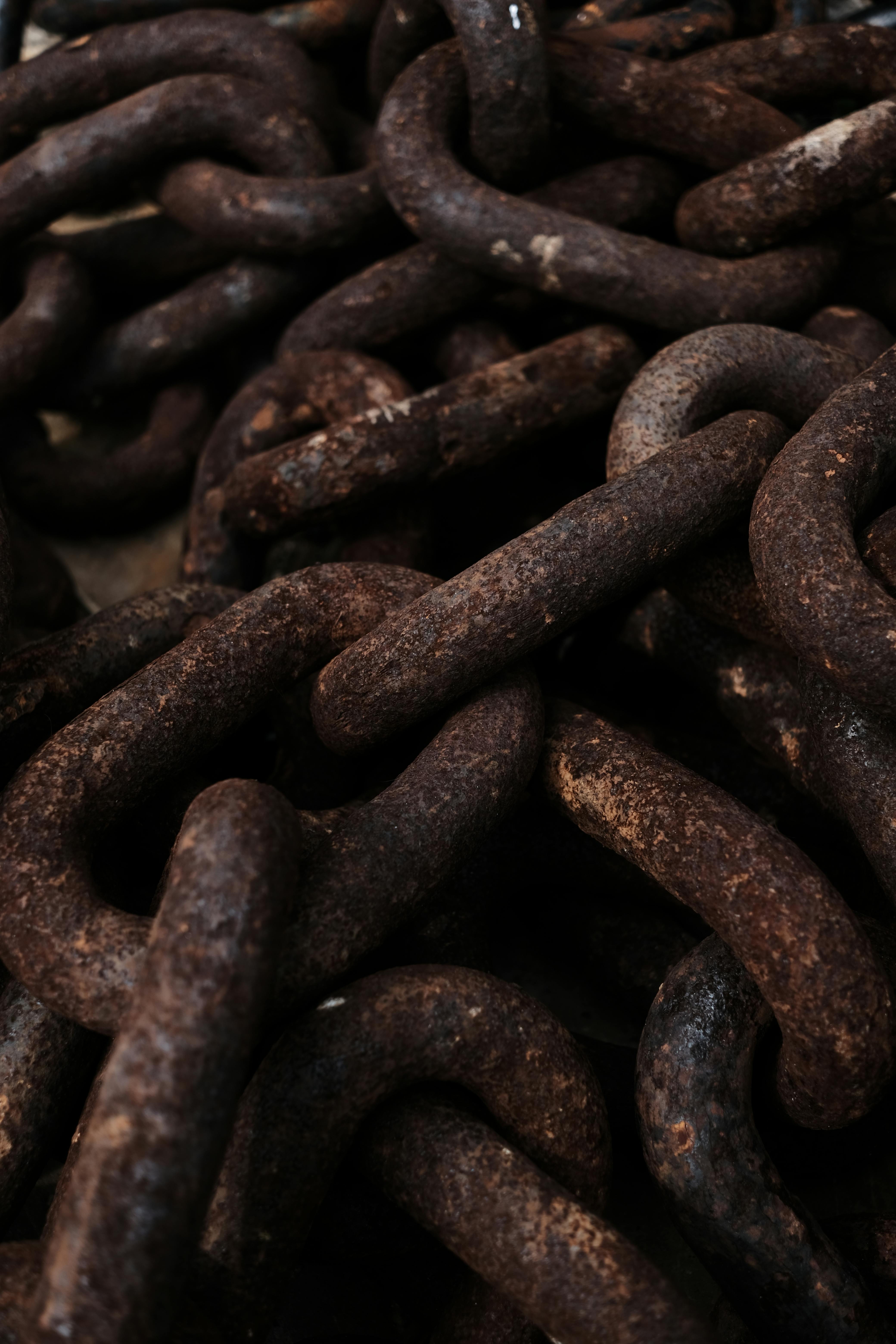 Detailed shot of interconnected rusty metal chains displaying texture and decay.