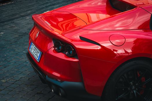 Close-up of a sleek red sports car in Rome, showcasing its luxurious design.