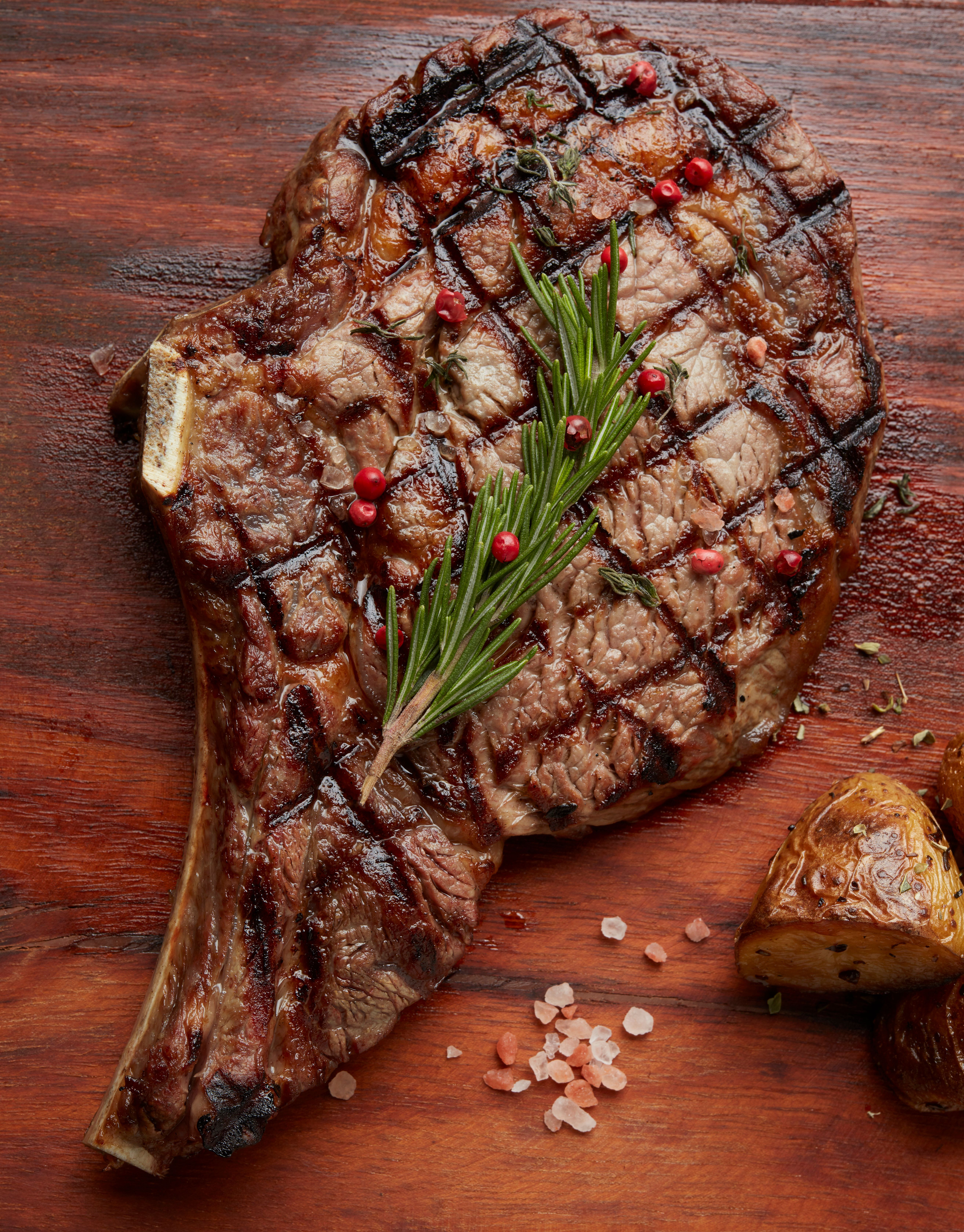 Grilled Ribeye Steak with Seasoning on Wooden Board · Free Stock Photo