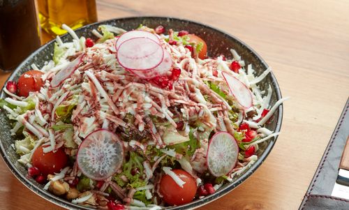Free Colorful vegetable salad featuring radish slices, cherry tomatoes, pomegranate seeds, and cheese. Stock Photo