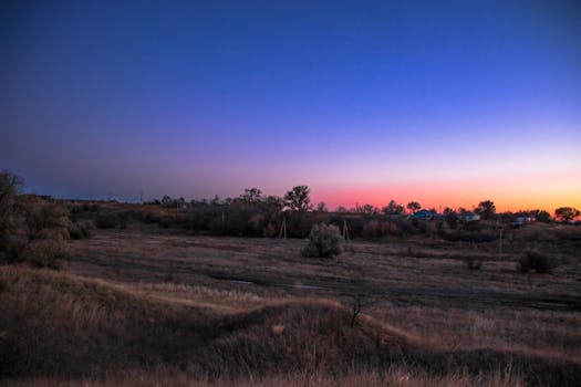黄昏的天空下，宁静的农村景观正从白天过渡到夜晚