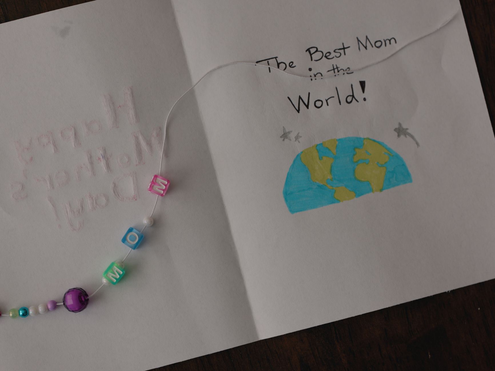 Handmade Mother's Day card featuring beaded bracelet and heartfelt message.