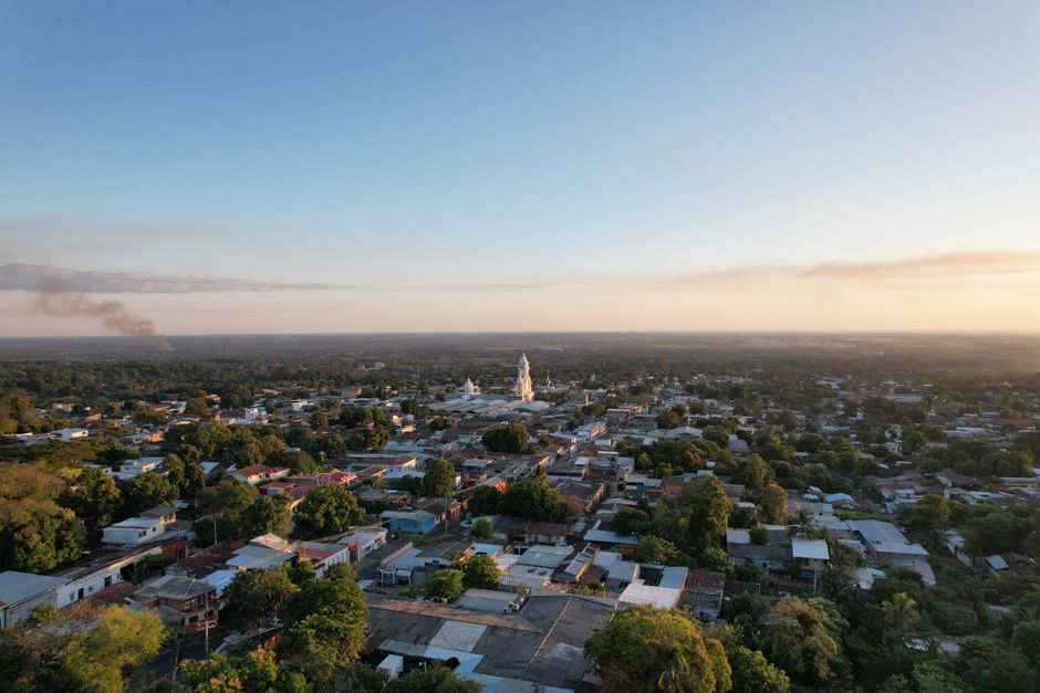 Scenic aerial view of Zacatecoluca in El Salvador during a beautiful summer sunset with lush greenery and distant smoke.