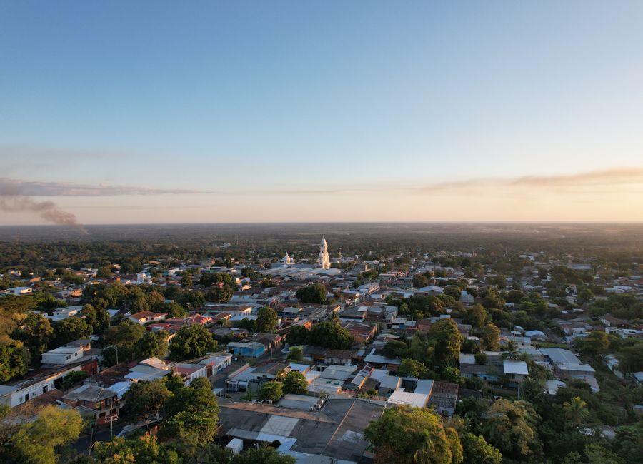 Scenic aerial view of Zacatecoluca in El Salvador during a beautiful summer sunset with lush greenery and distant smoke.