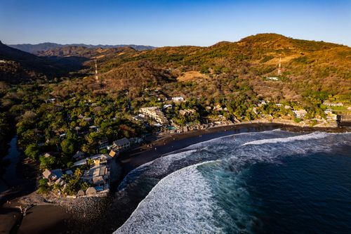 Free Stunning aerial view of El Zonte Beach, showcasing the coastline and lush hillsides in El Salvador. Stock Photo