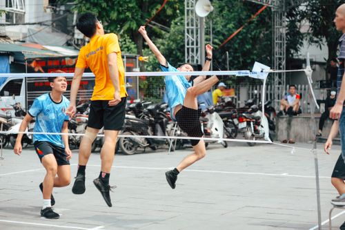 Free Dynamic shot of young men playing badminton on a vibrant street. Stock Photo