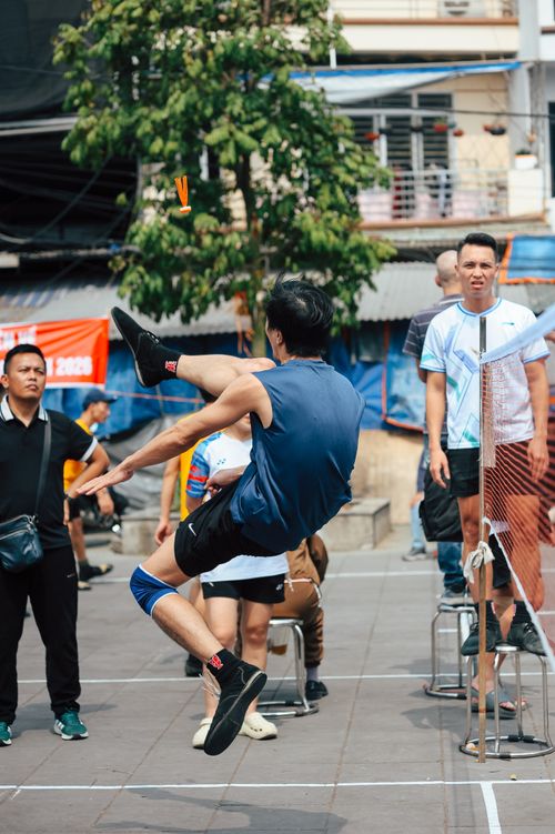 Free Action-packed scene of a shuttlecock game with players in an urban outdoor setting. Stock Photo