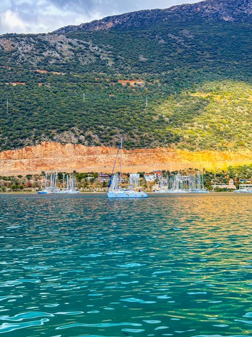 Free Colorful marina in Kaş, Antalya, Türkiye, with yachts and lush mountains in the background. Stock Photo