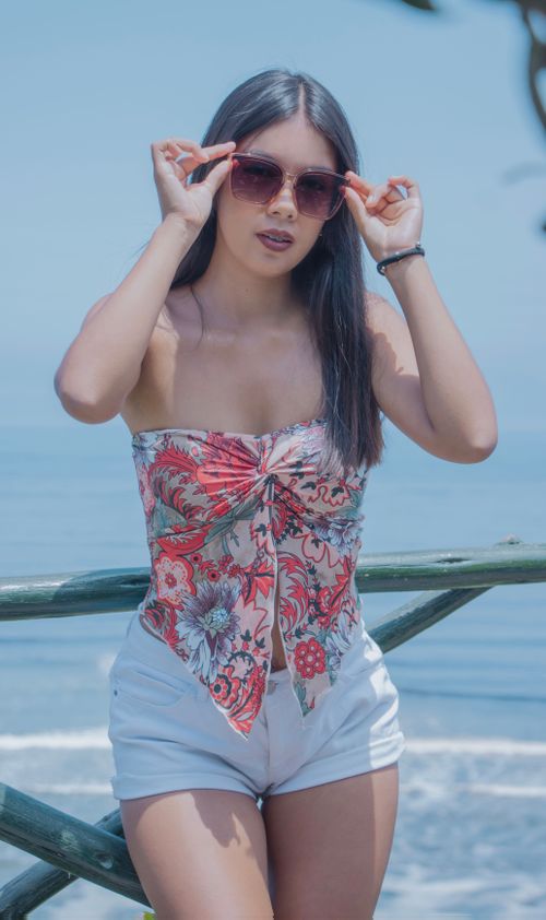 Free Young woman in sunglasses poses stylishly by the ocean in Callao, Perú. Stock Photo