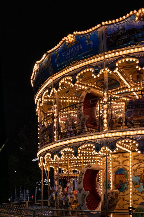 Free A beautifully lit carousel at night, capturing the magical ambiance of an amusement park. Stock Photo