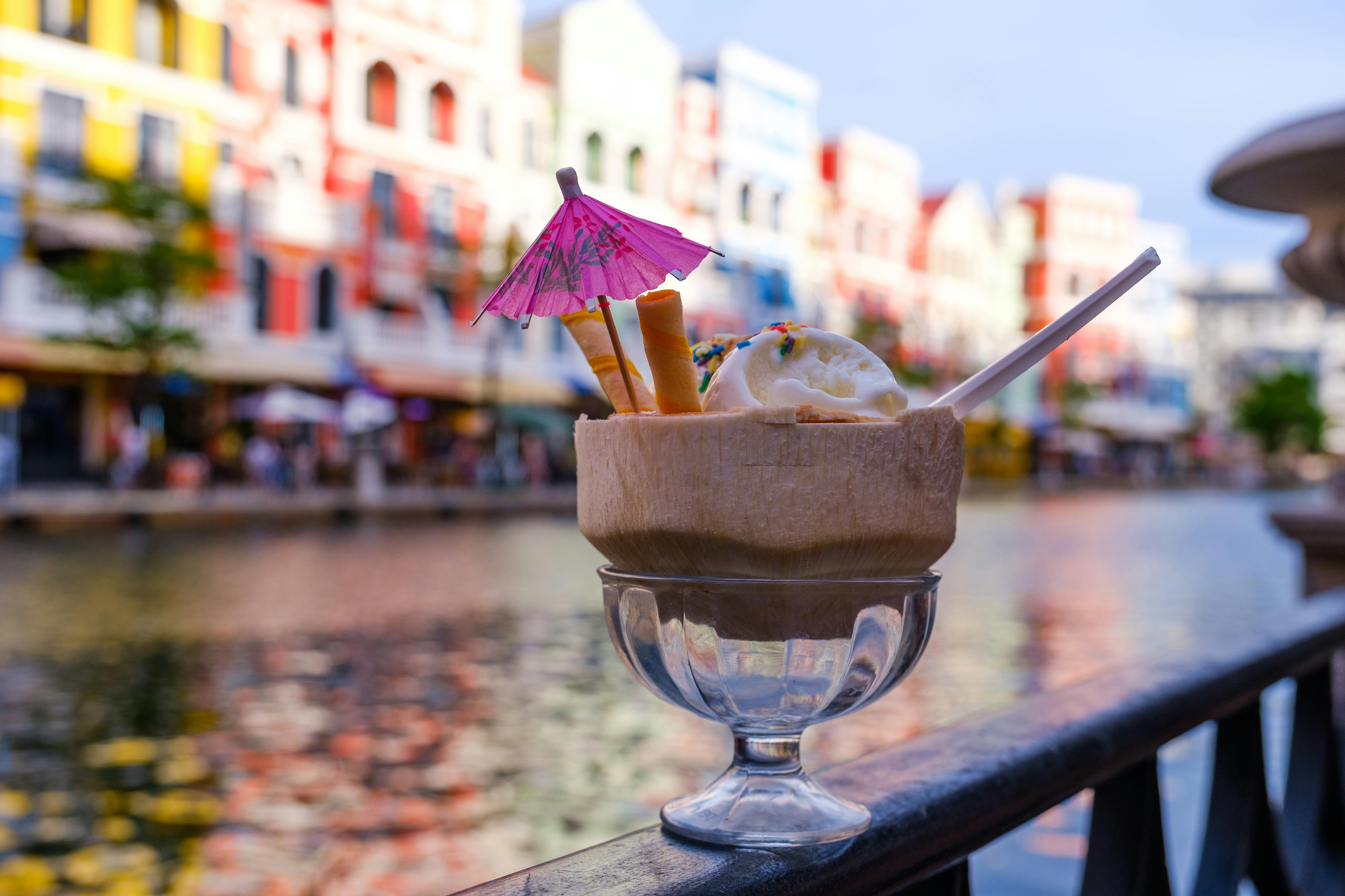 Two children happily eating colorful gelato cones in a bustling Roman piazza, surrounded by historic buildings.