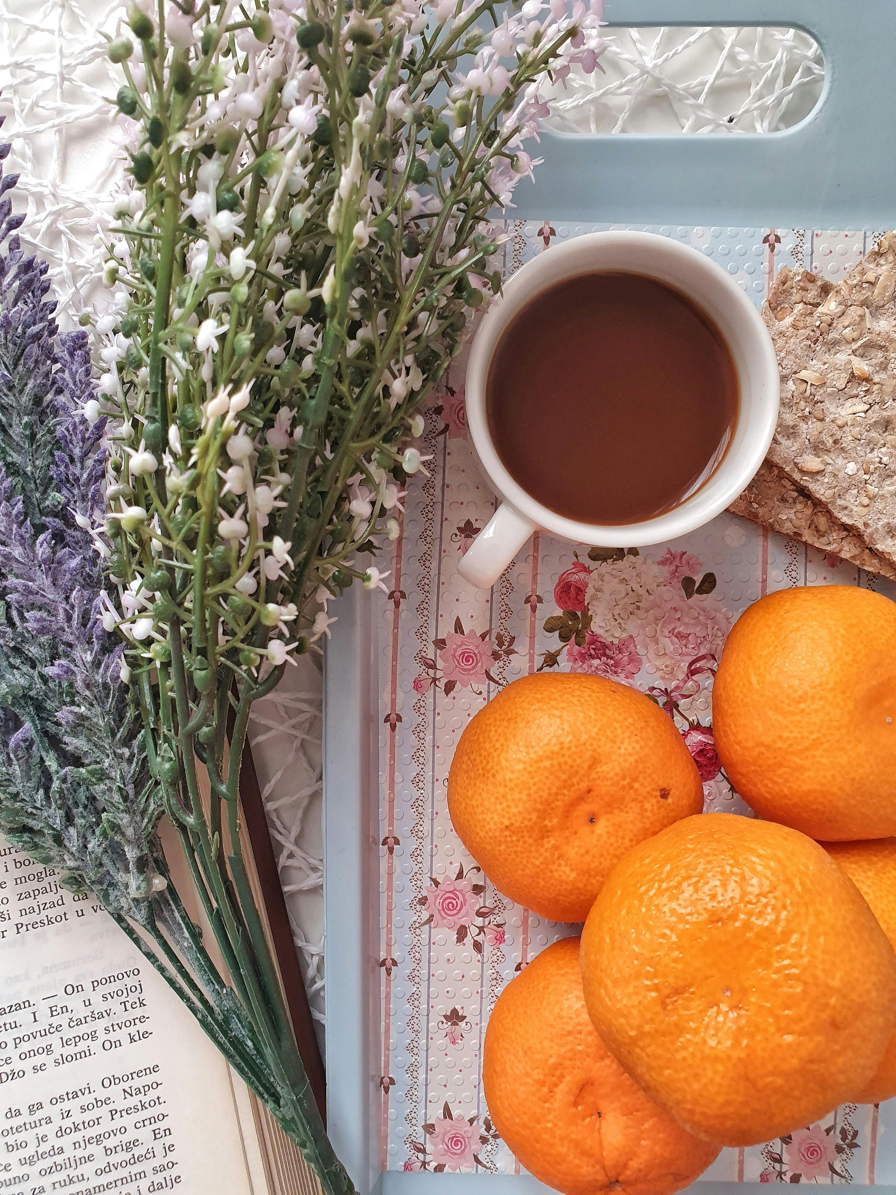 orange fruit beside white ceramic mug