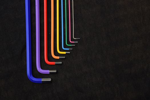 A vibrant, orderly set of Allen wrenches in a rainbow spectrum against a dark background.