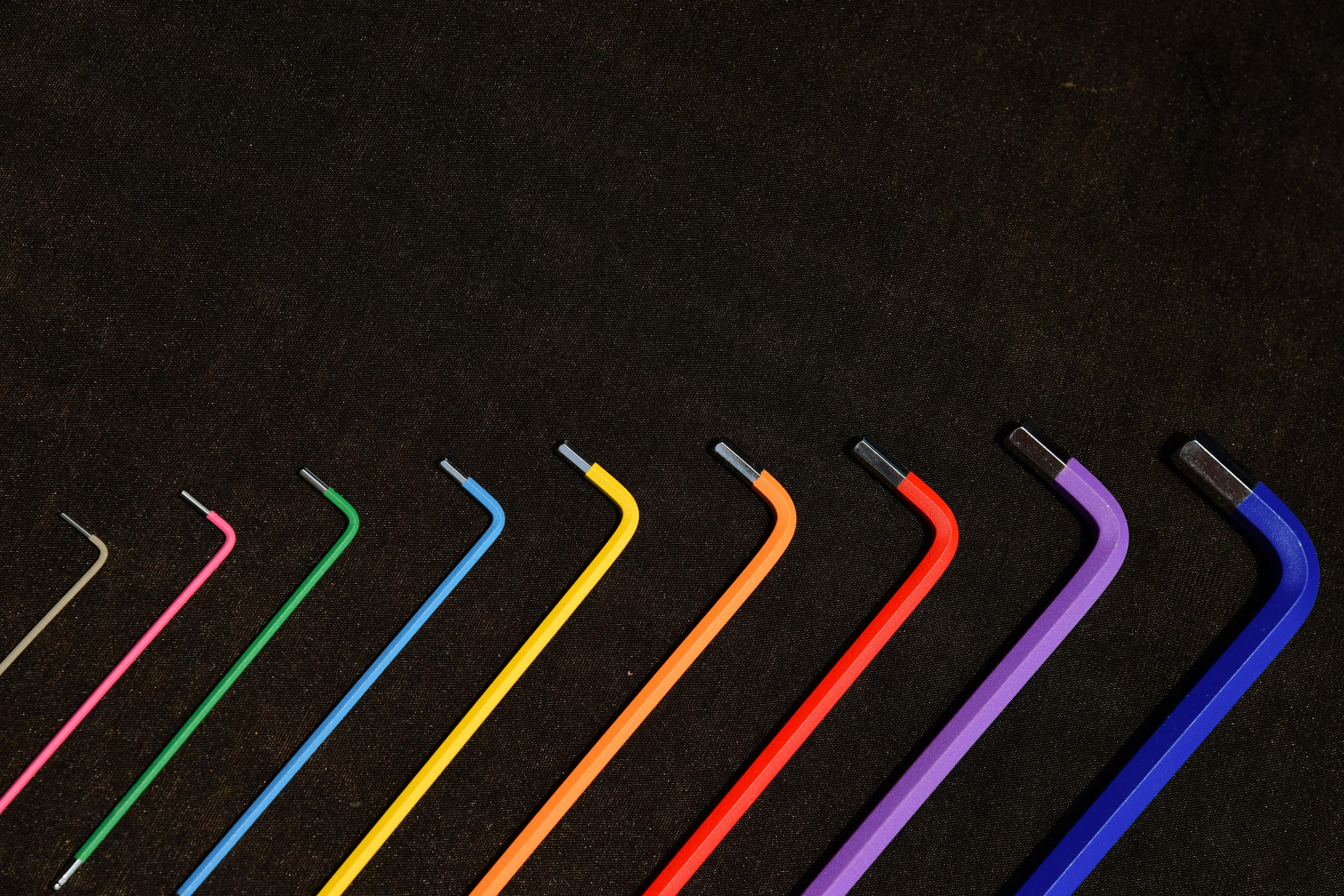 Vibrant set of hex keys in rainbow colors organized in a neat pattern on a dark backdrop.