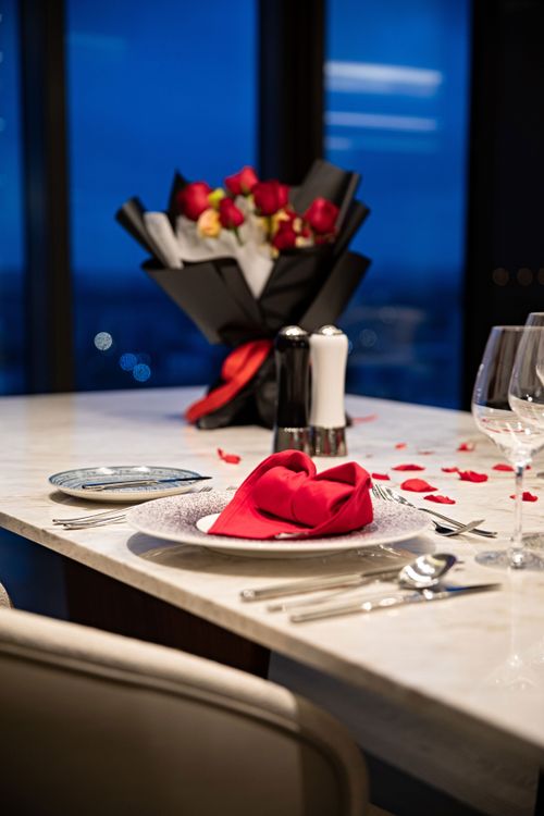 Free Stylish table set for a romantic dinner with roses and red napkins. Stock Photo