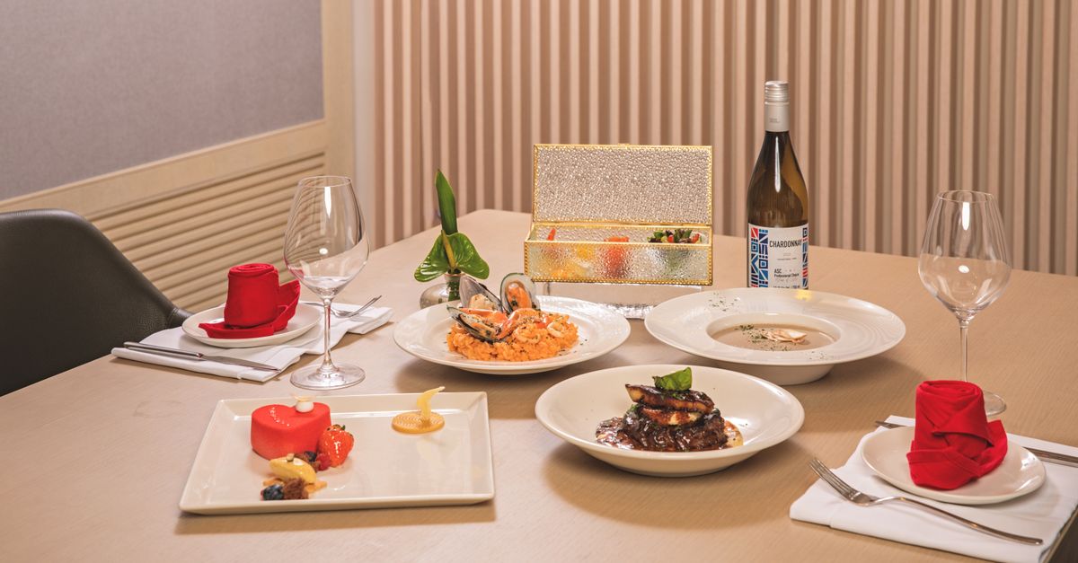 Luxurious dining setup with gourmet seafood, wine, and desserts on an elegantly dressed table.