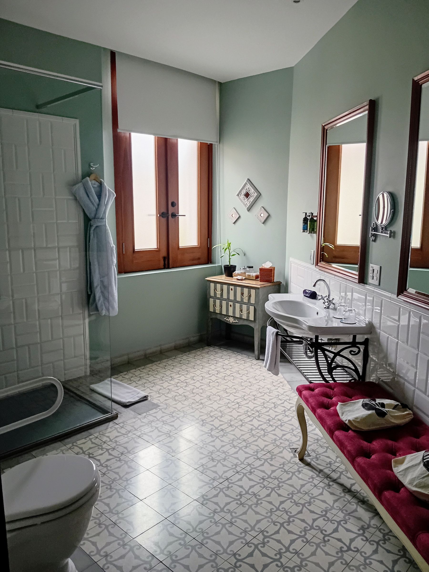Traditional bathroom with warm wood vanity, framed cabinetry and classic mirror