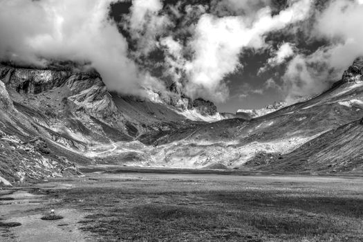 Stunning black and white photograph of a Swiss alpine valley under dramatic cloud cover.