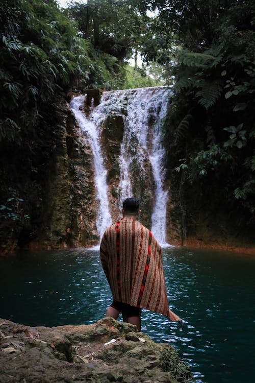 Free Man Standing in Front of Waterfalls Stock Photo