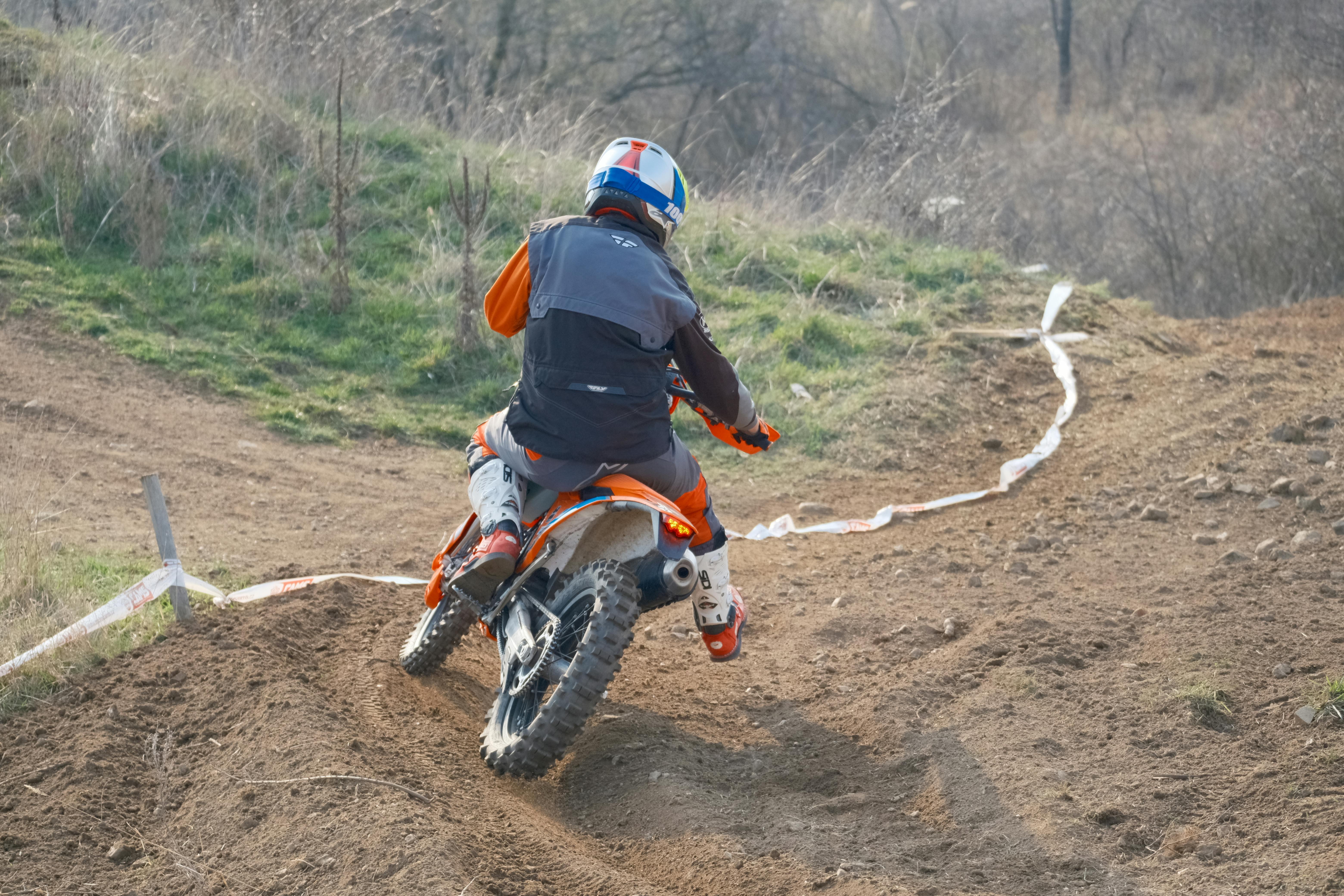 A motorcyclist rides an off-road bike on a dirt track in the Jihomoravský kraj, emphasizing adventure
