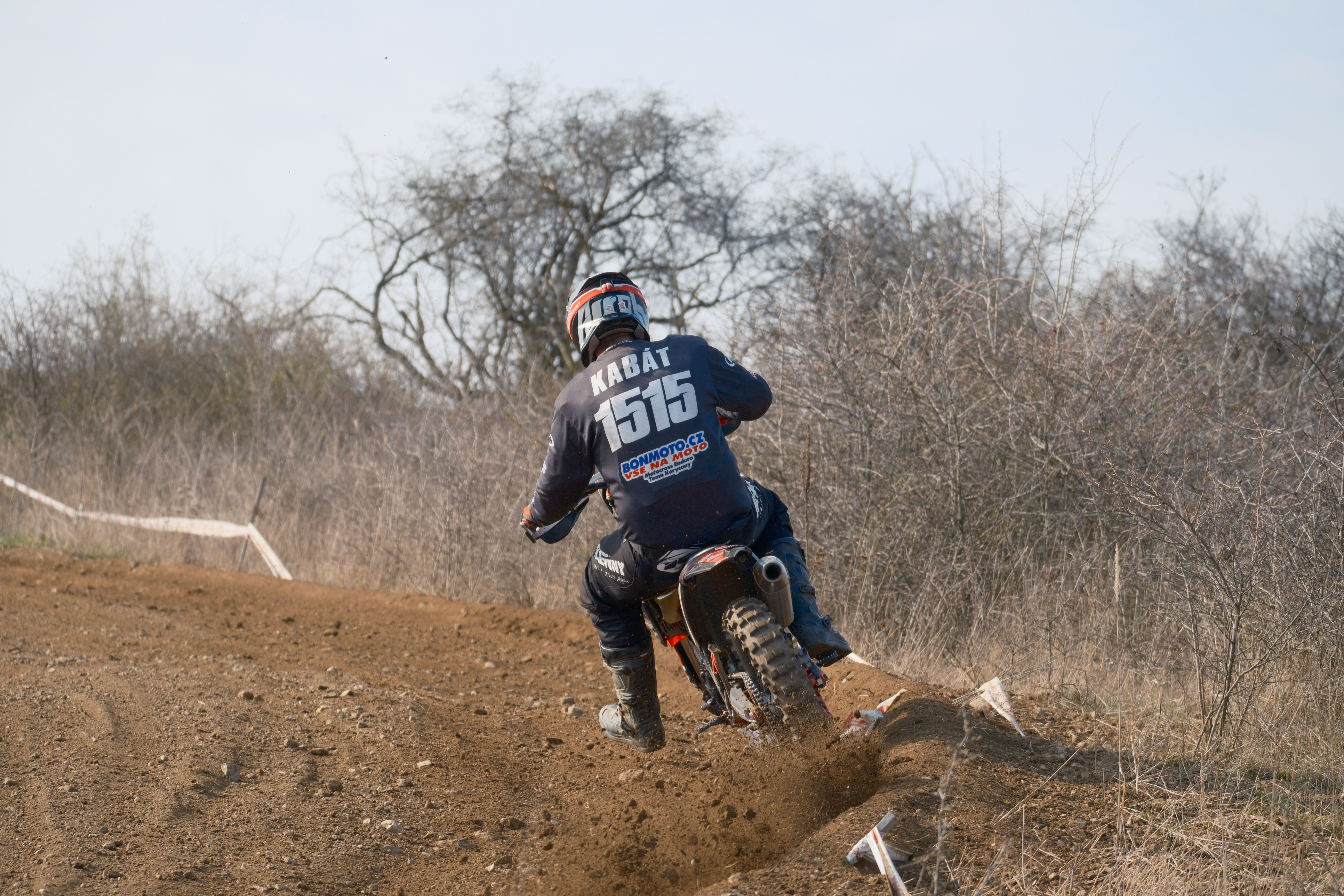 Rider on motocross bike takes on a challenging dirt track in Jihomoravský kraj, Česko.
