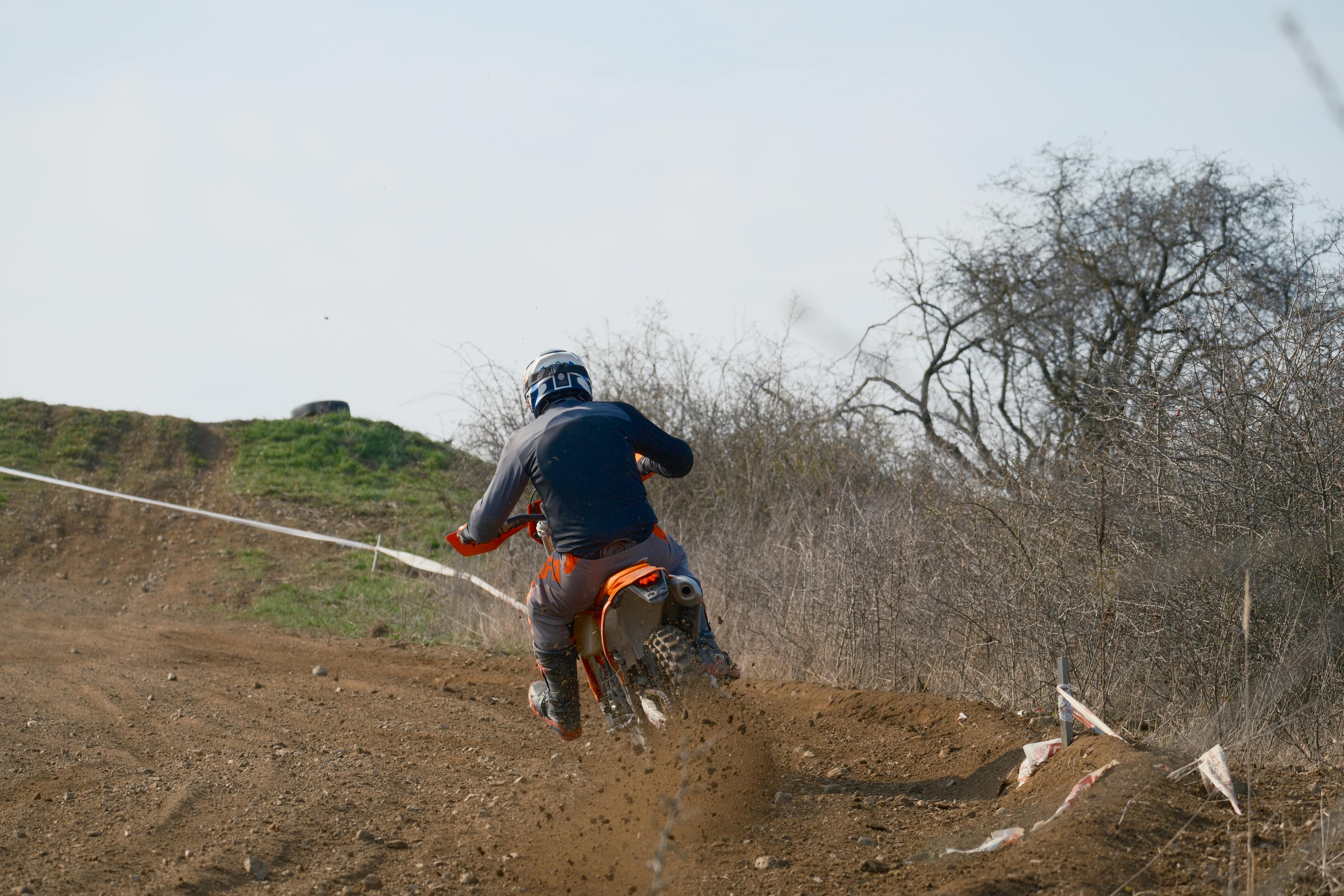 Dirt biker racing through a rugged outdoor track, showcasing thrilling off-road action.