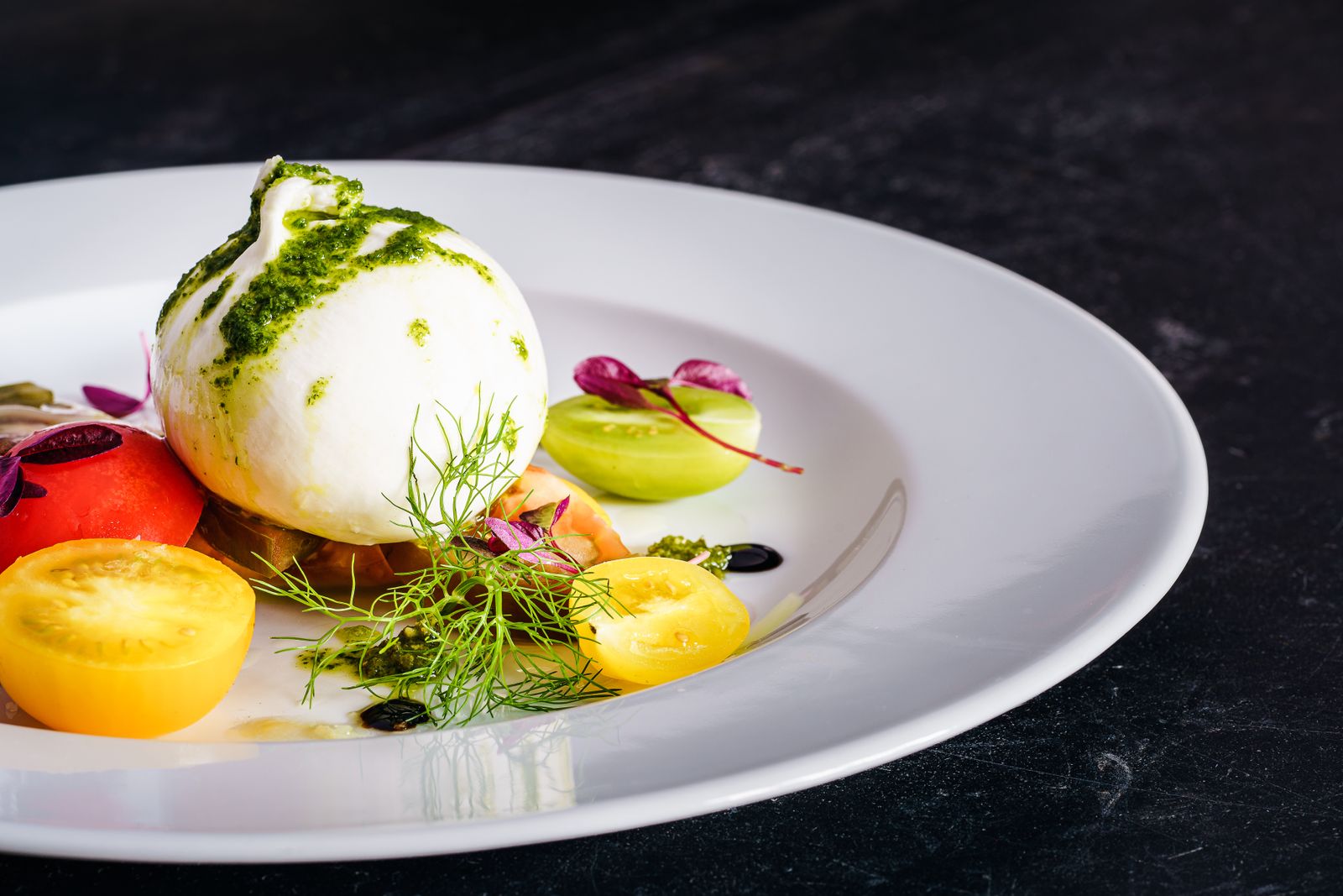 Burrata with heirloom tomatoes and pesto on a white plate — Sebastian Coman Photography on Pexels