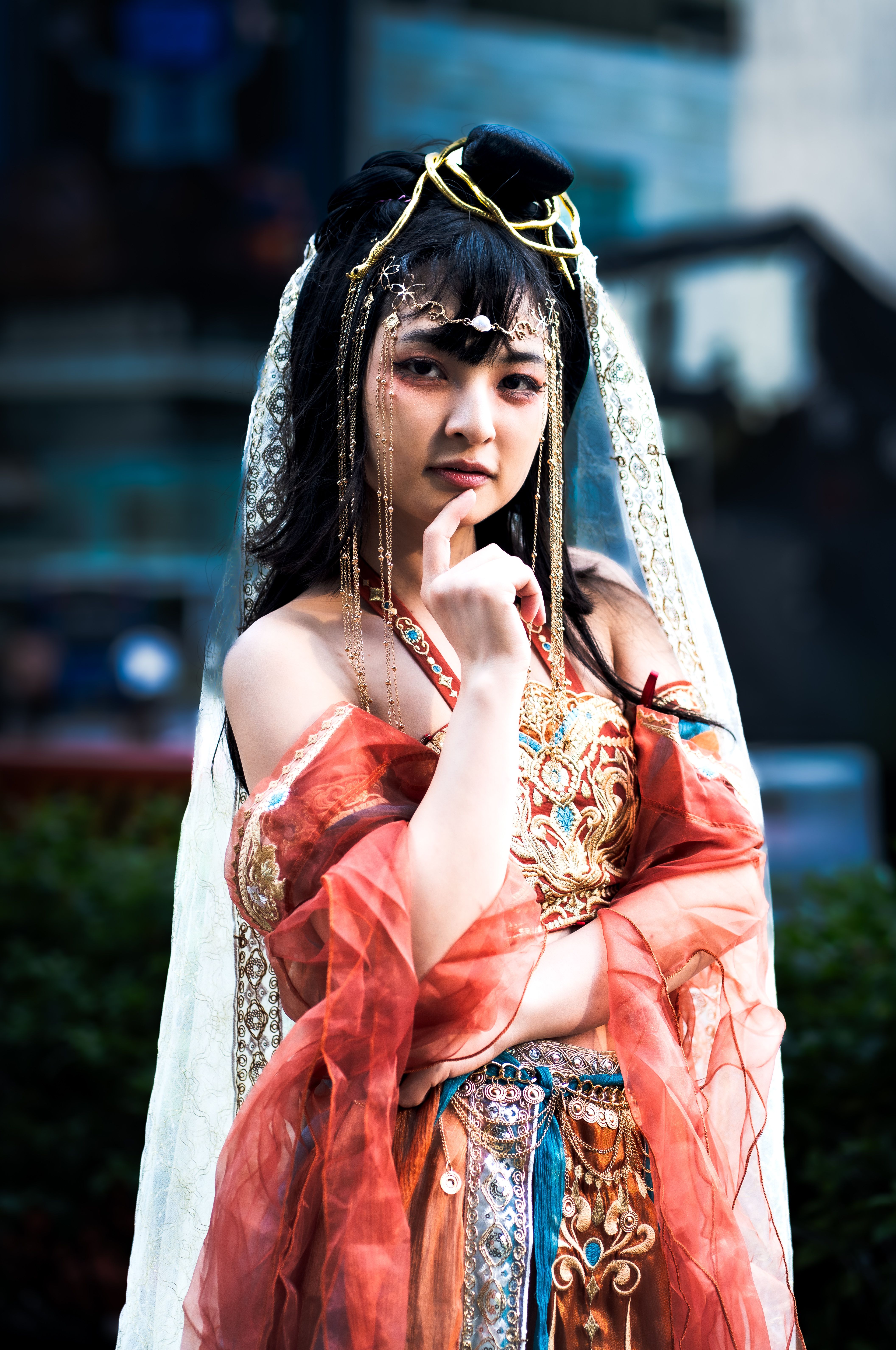 A woman in an ornate, traditional costume poses confidently outdoors in Jakarta.
