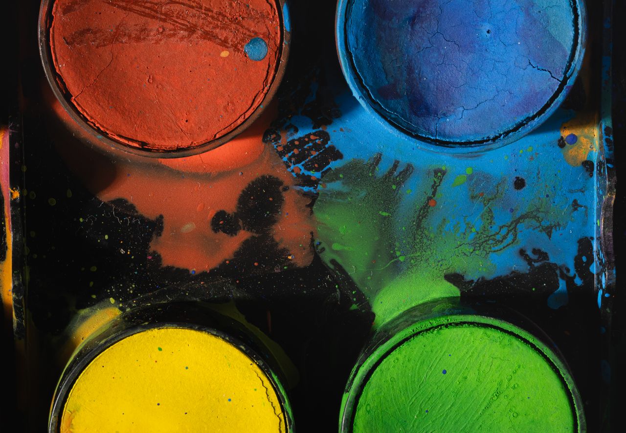 a close up of a colorful paint palette showing vibrant pigments in red