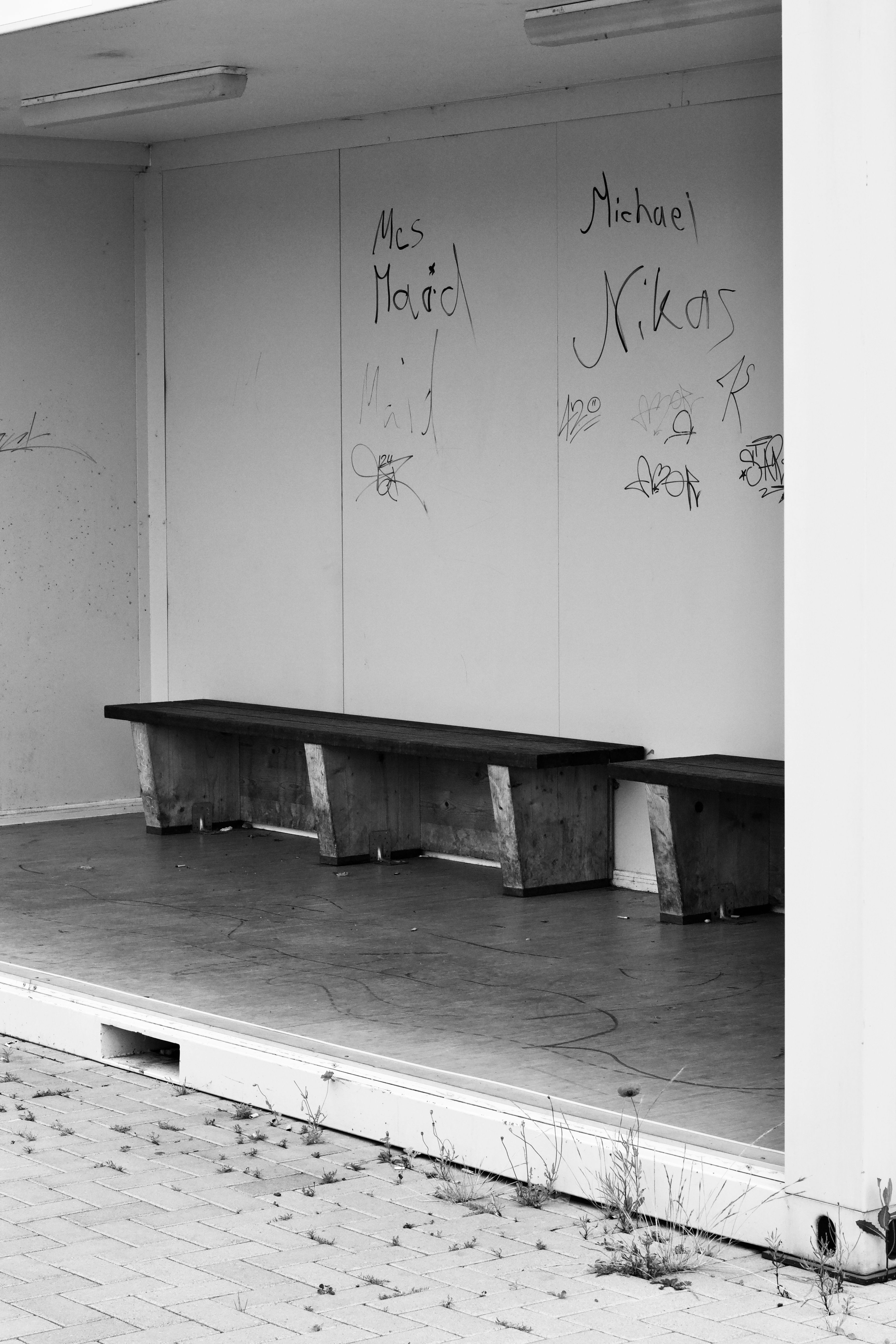 Black and white photo of an empty urban stage with graffiti, highlighting solitude.