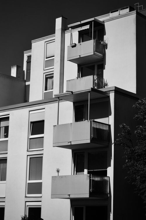 Free Black and white photo of a modern apartment building with balconies, featuring minimalist architecture. Stock Photo