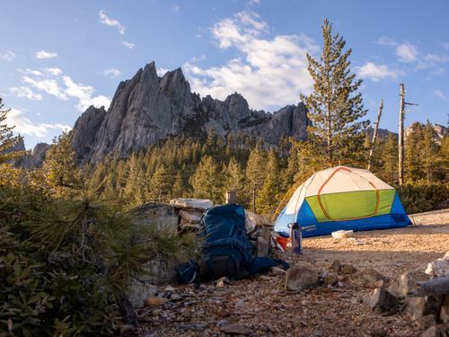 Free Camping scene with a tent at Castle Crags, Castella, CA. Serene wilderness and rocky peaks in view. Stock Photo