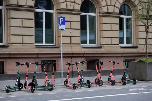 Row of electric scooters parked on a street in downtown Frankfurt, Germany.