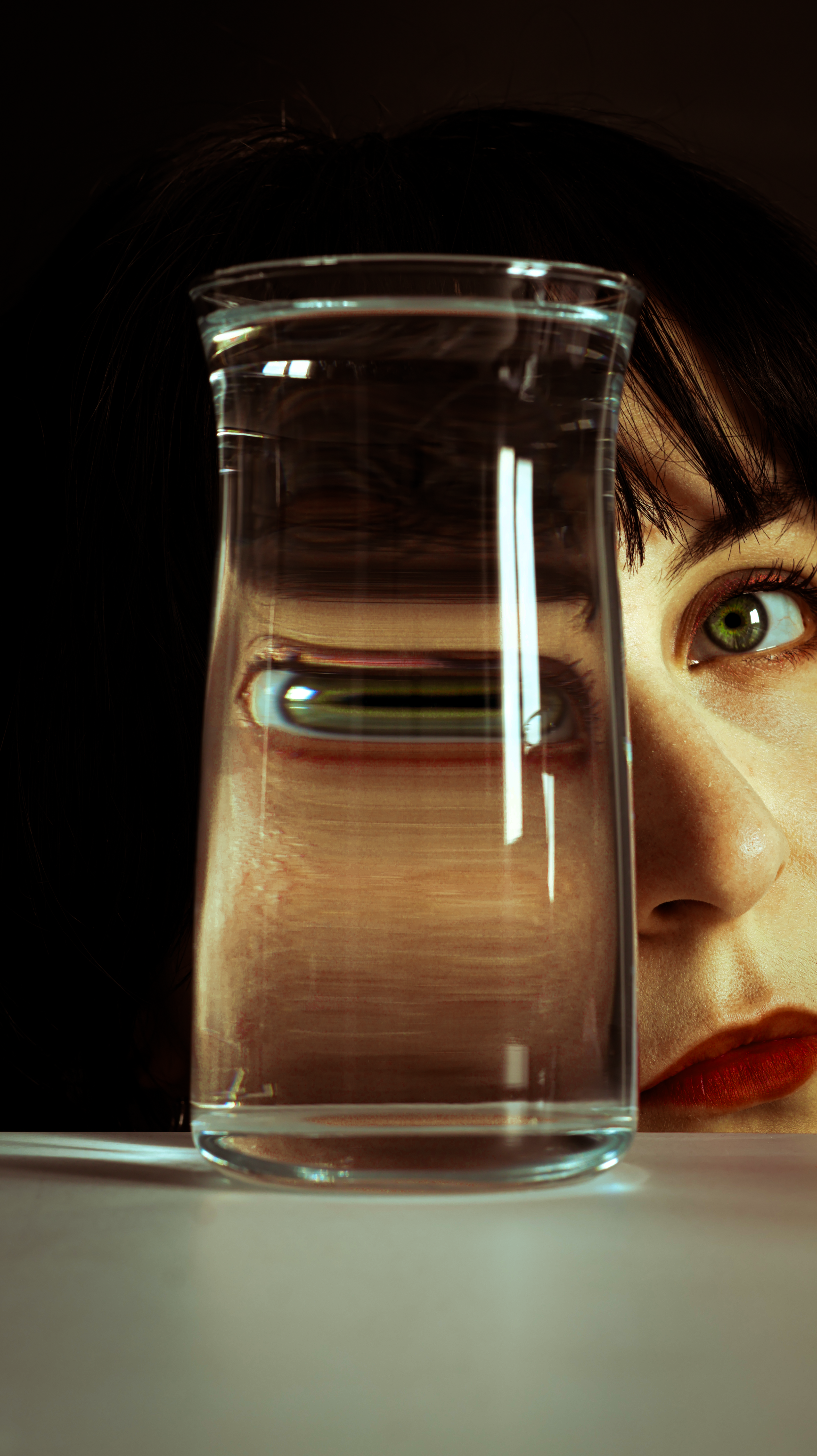 Creative photo using glass refraction to alter perception of face.