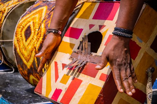Free Close-up of hands playing a colorful, traditional drum with geometric patterns. Stock Photo