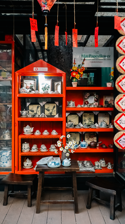 Free Charming traditional Asian shop with vibrant red shelves displaying teapots and ceramic art. Stock Photo