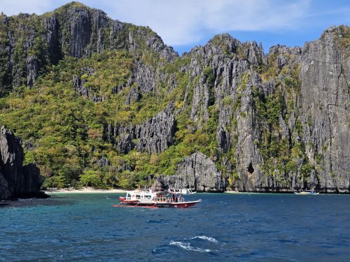 Free Enjoy a breathtaking view of boats by the limestone cliffs of El Nido, Philippines. Stock Photo