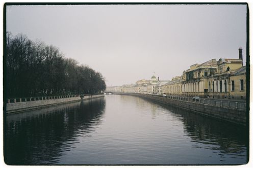 Free Serene canal flanked by historic buildings under a clear sky in an urban setting. Stock Photo