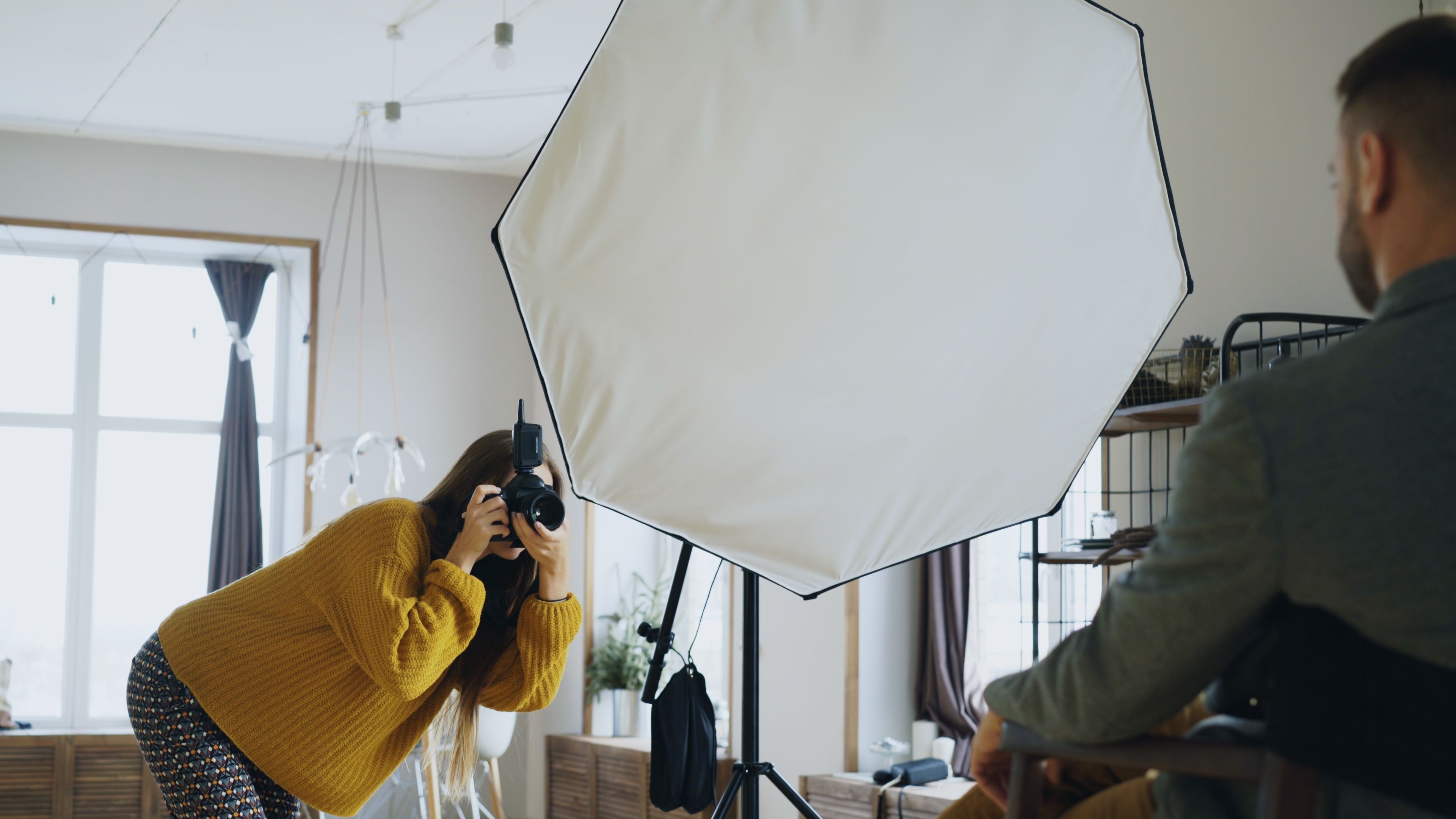 A photographer taking portraits in a modern indoor studio setting.