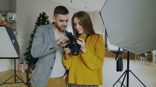 Free A couple reviews camera photos in a photography studio. Professional setup. Stock Photo