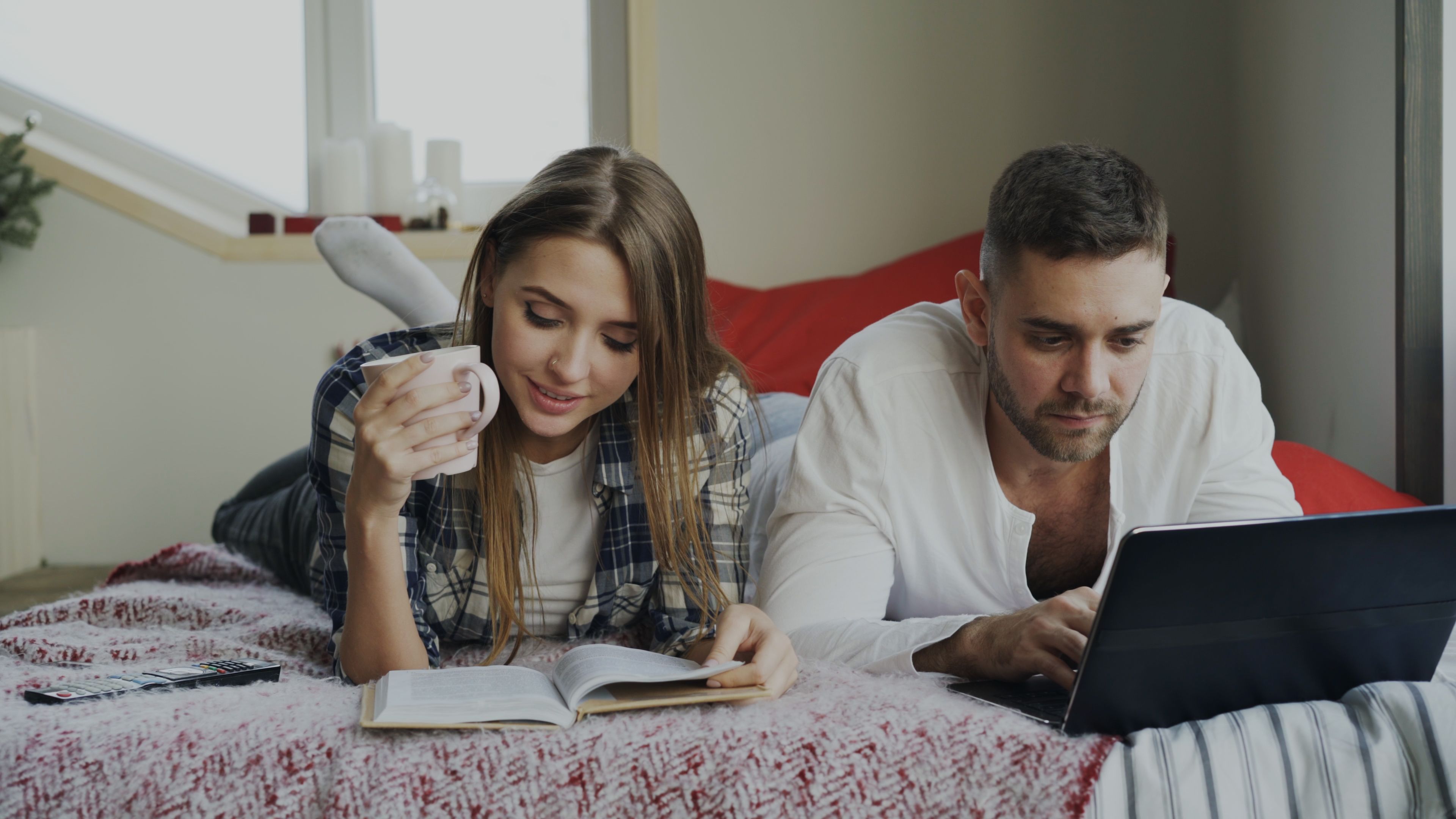 Couple using a laptop to book their next affordable island trip - cheap island getaways for couples