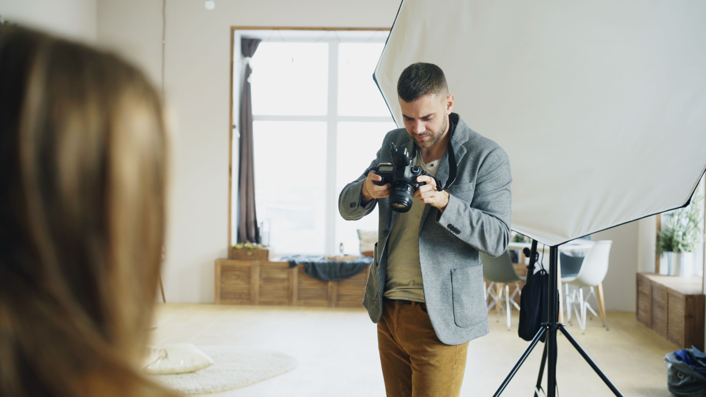 Photographer reviewing camera while setting up a shot in a studio.