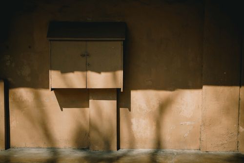 Free Artistic shadow play on a rustic wall with closed cabinet in soft light. Stock Photo