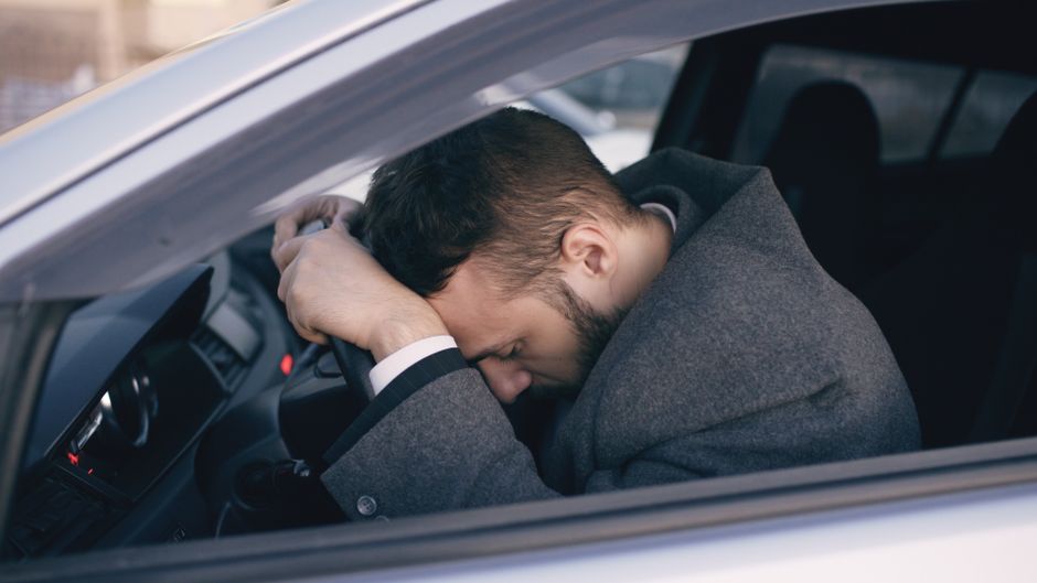 driver struggling with a stiff steering wheel in a luxury car driver struggling with a stiff steering wheel in a luxury car