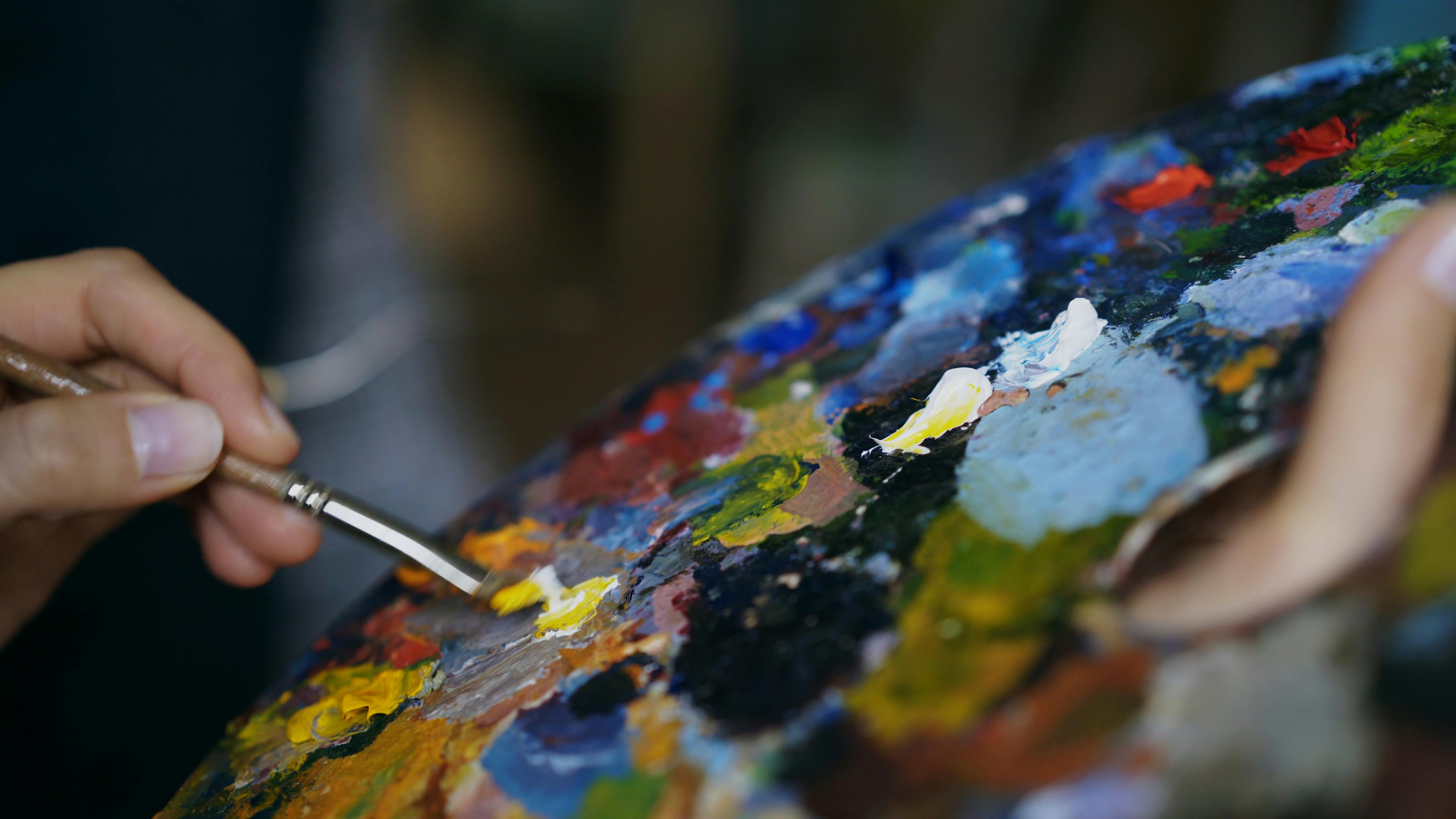 Artistic close-up of an artist mixing colors on a palette with precision.