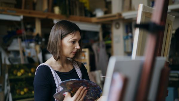 Teacher working at an easel in her studio — photo by Vitaly Gariev on Pexels