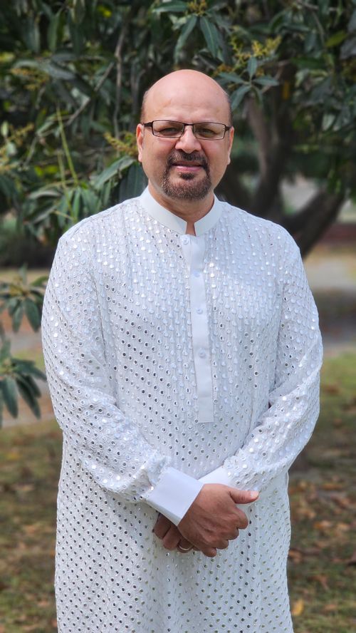 Free Portrait of a man wearing traditional white attire in an outdoor setting. Stock Photo