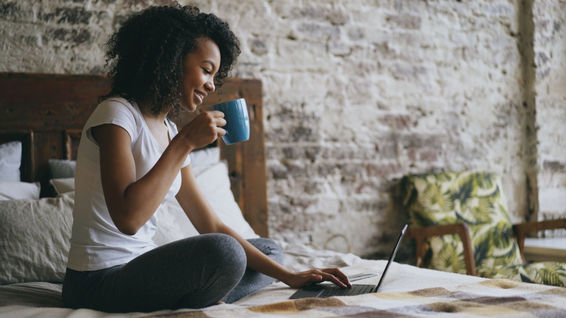 Person writing morning goals in a notebook beside a cup of tea in an Indian home setting