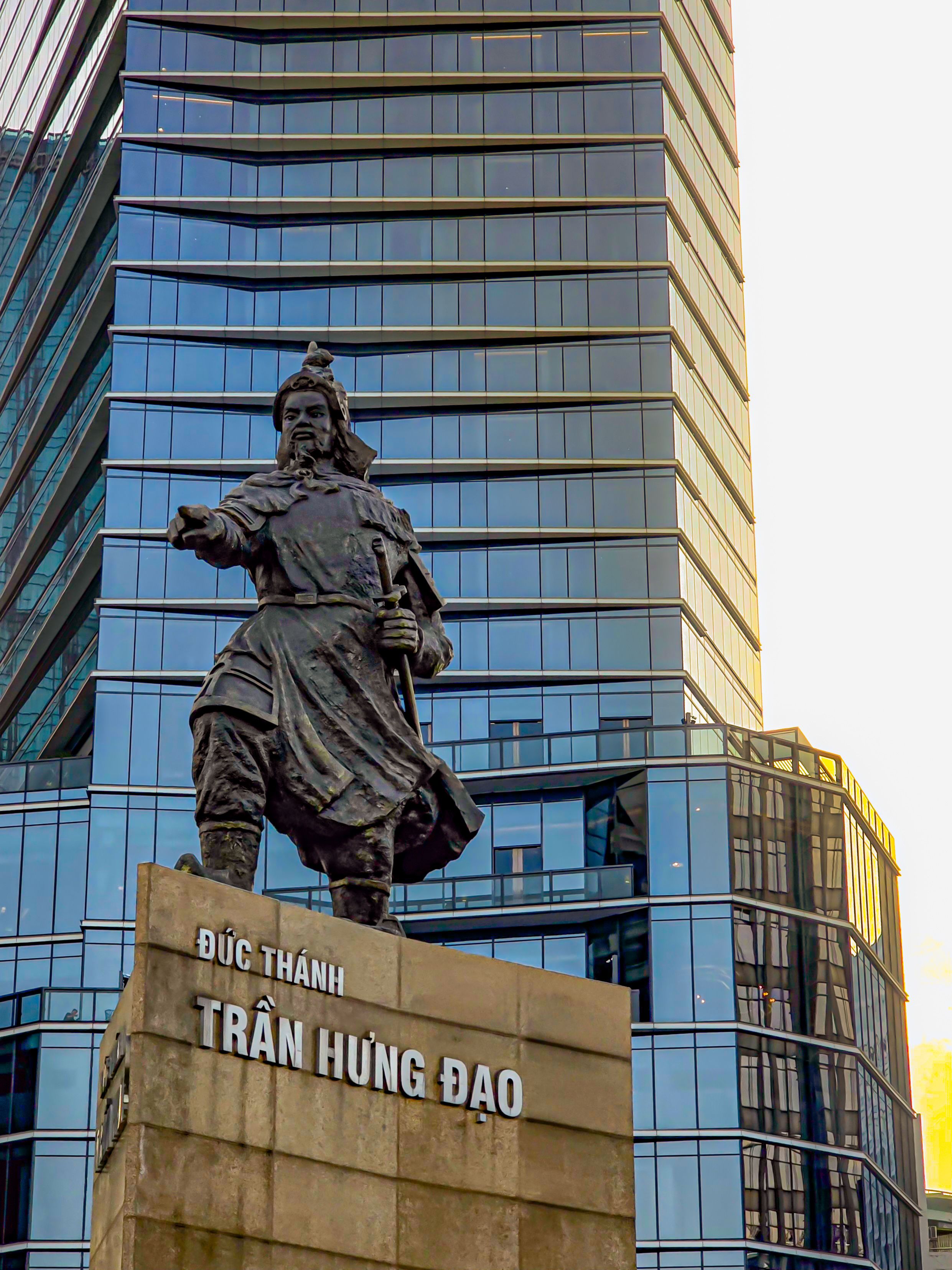Stunning view of the Trần Hưng Đạo statue against modern architecture in Ho Chi Minh City, Vietnam.