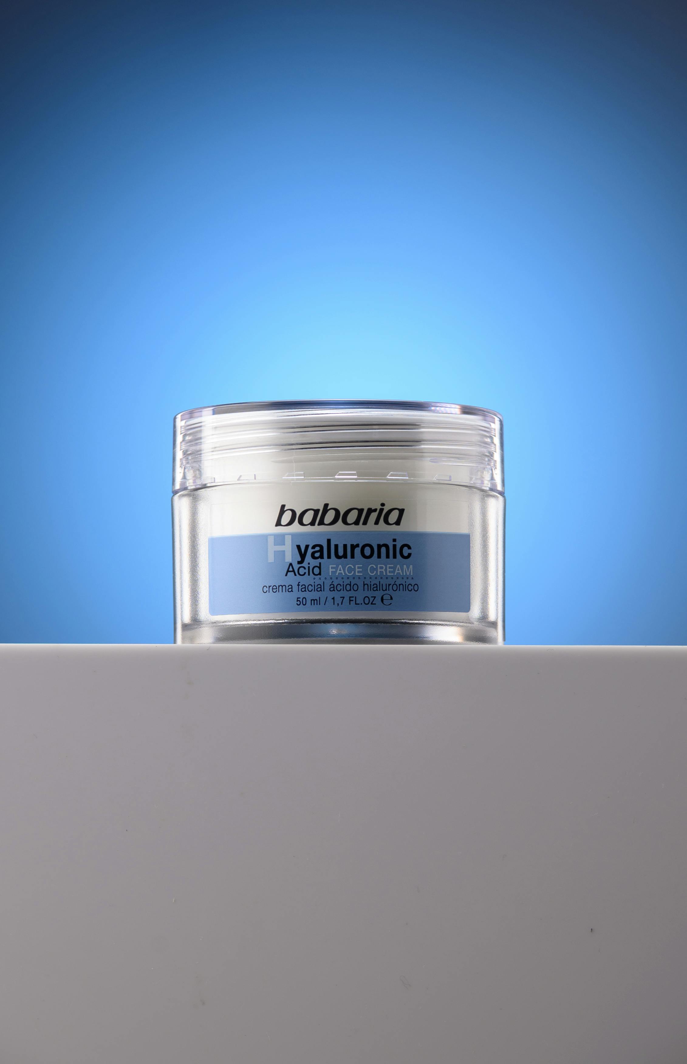 Hyaluronic acid face cream jar on a blue gradient background.
